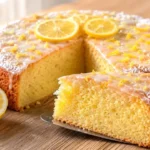 Saftiger Zitronen Joghurt Kuchen mit glänzender Zitronenglasur, lockerer goldgelber Krume und frischem Zitronenabrieb.
